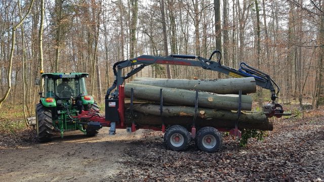 Traktor mit Rückewagen und Stammholz